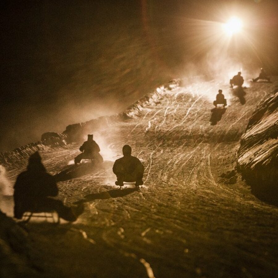 Rodelfahrer bei Nacht auf der Rodelpiste. | © IDM Südtirol