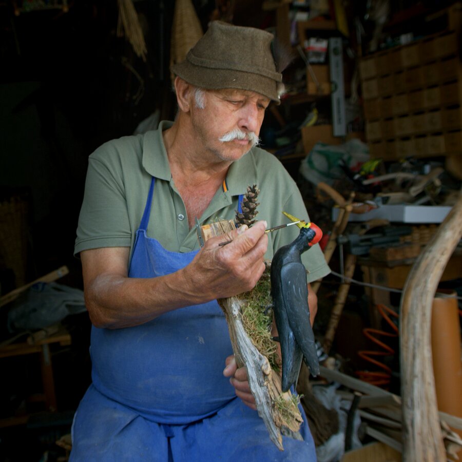 Ein Mann beim Fertigstellen seines geschnitzten Kunstwerkes. | © RAW Media