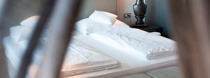 Ein Bett in einer Unterkunft.  | © Alex Filz