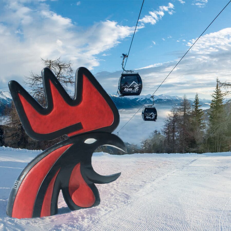 Der Kronplatz Hahn strahlt auf der Piste bei strahlendem Sonnenschein unter der Kabinenbahn hervor. | © Gianvito Coco