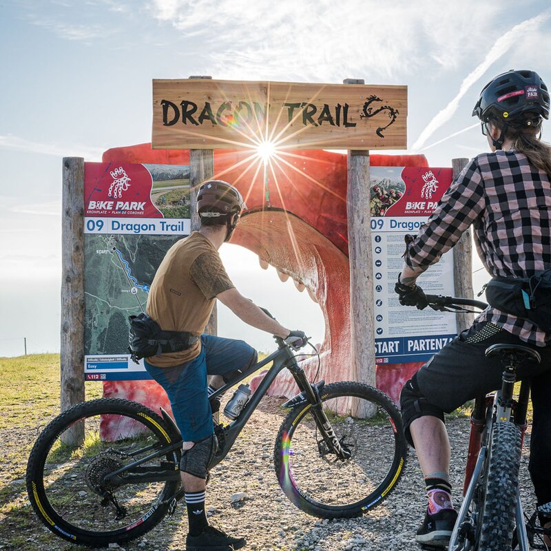 Ein Mountainbiker und eine Mountainbikerin mit ihren Rädern beim Eingang des Dragon Trails. | © Harald Wisthaler