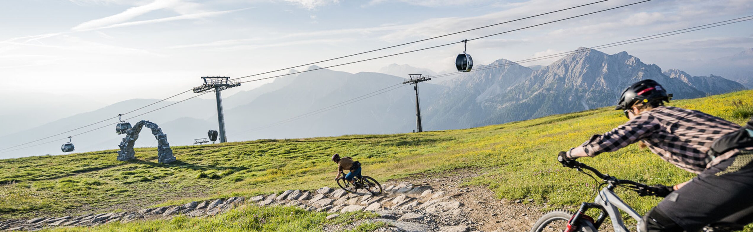 Eine Mountainbikerin und ein Mountainbiker unterwegs auf den Trails im Kronplatz Bike Park. | © Harald Wisthaler