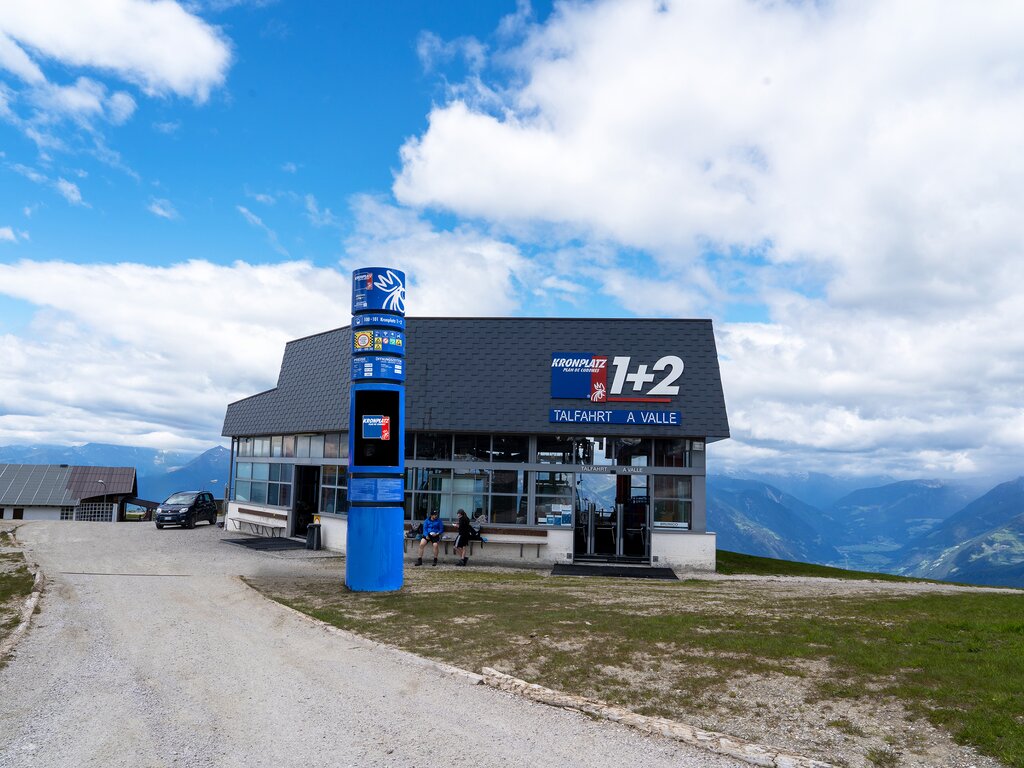 Die Bergstation der Gondelbahn Kronplatz 1+2 vor dem Hintergrund der Bergkulisse und leicht bewölktem Himmel. | © Skirama Kronplatz