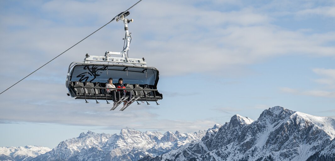 Skifahrer fahren bei Sonnenstrahlen mit dem Lift Plateau. | © Harald Wisthaler
