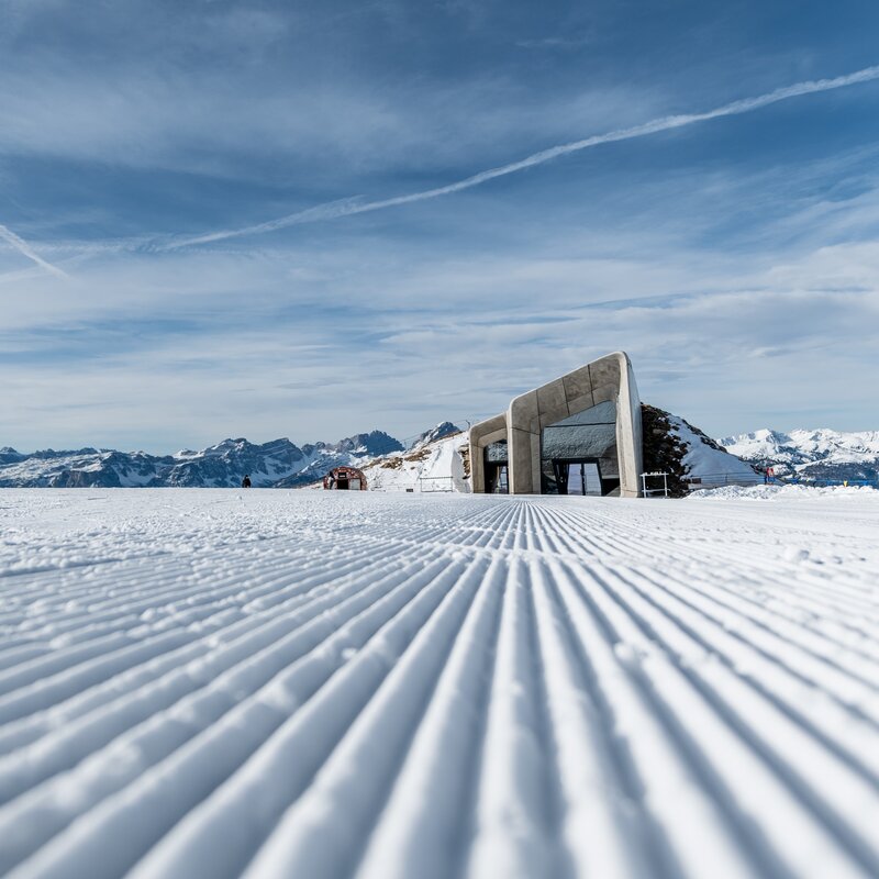 Blick auf eine perfekt präparierte Piste und im Hintergrund das Messner Mountain Museum. | © Gianvito Coco