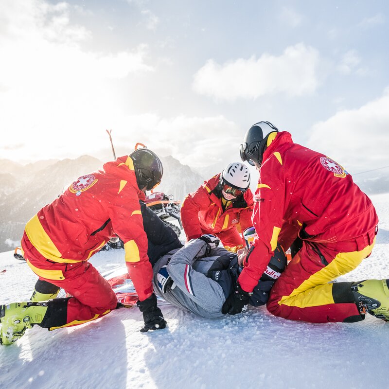 Die Mitarbeiter von der Pistenrettung helfen einer verletzten Person auf der Piste. | © Harald Wisthaler