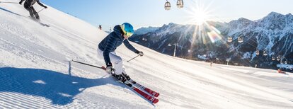 Zwei Skifahrer auf einer Piste bei strahlendem Sonnenschein in den Dolomiten. | © Harald Wisthaler