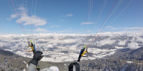 Ein Paragleiter im Winter oberhalb von Bruneck. | © Tandemflights Kronplatz