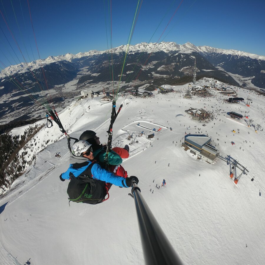 Paragleiter über dem Talkessel von Bruneck im Winter. | © Kronfly Tandem