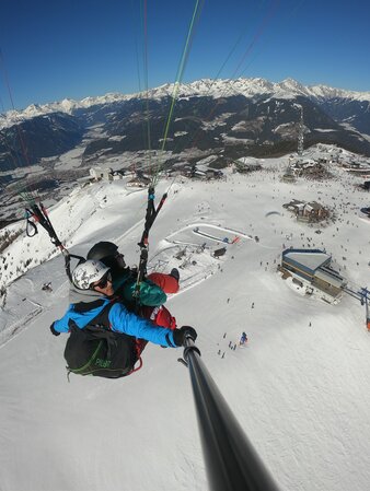 Paragleiter über dem Talkessel von Bruneck im Winter. | © Kronfly Tandem